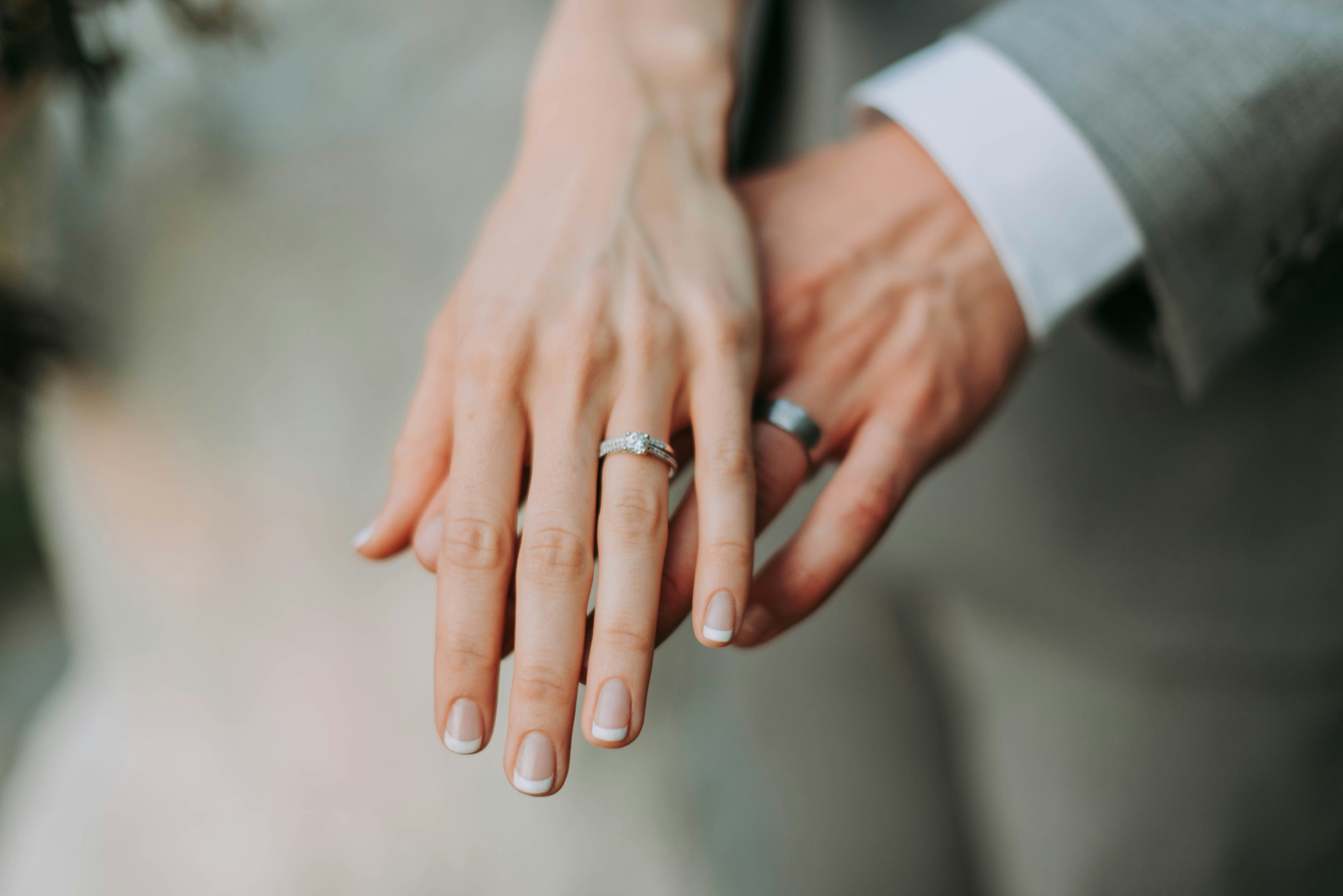 Detalle editorial de manos y anillos de boda